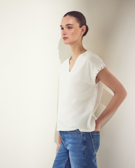 Woman El Corte Inglés - Camiseta de mujer manga corta con cuello pico y tachas en mangas.