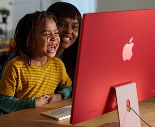 Una familia riéndose mientras ve una serie en el iMac.
