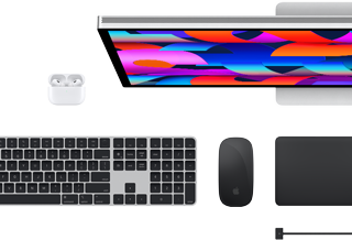 Vista superior de varios accesorios del Mac: un Studio Display, unos AirPods, un Magic Keyboard, un Magic Mouse y un Magic Trackpad.
