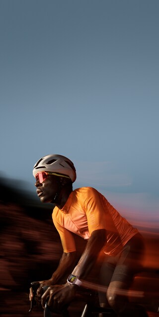 Imagen de una persona montando en bici con un Apple Watch Series 9 en la muñeca.